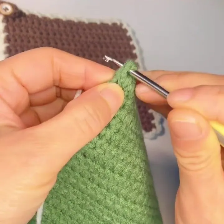Start the Edging from One Corner Now it’s time to crochet the edging.Choose one corner of the square and insert your hook into the corner stitch to begin the border.