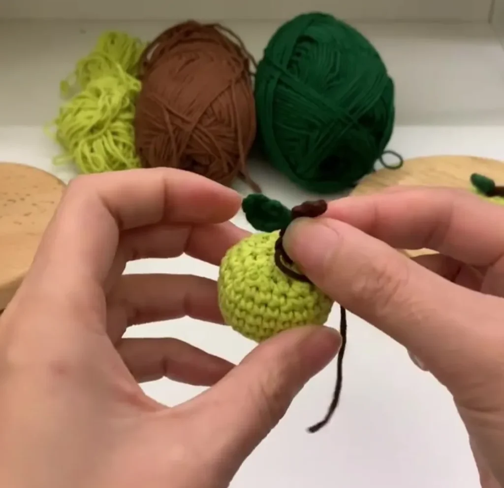 Crochet Apple ๐ Easy Mini Amigurumi Apple for Beginners 3 crochet apple top detail showing stem and leaf attachment