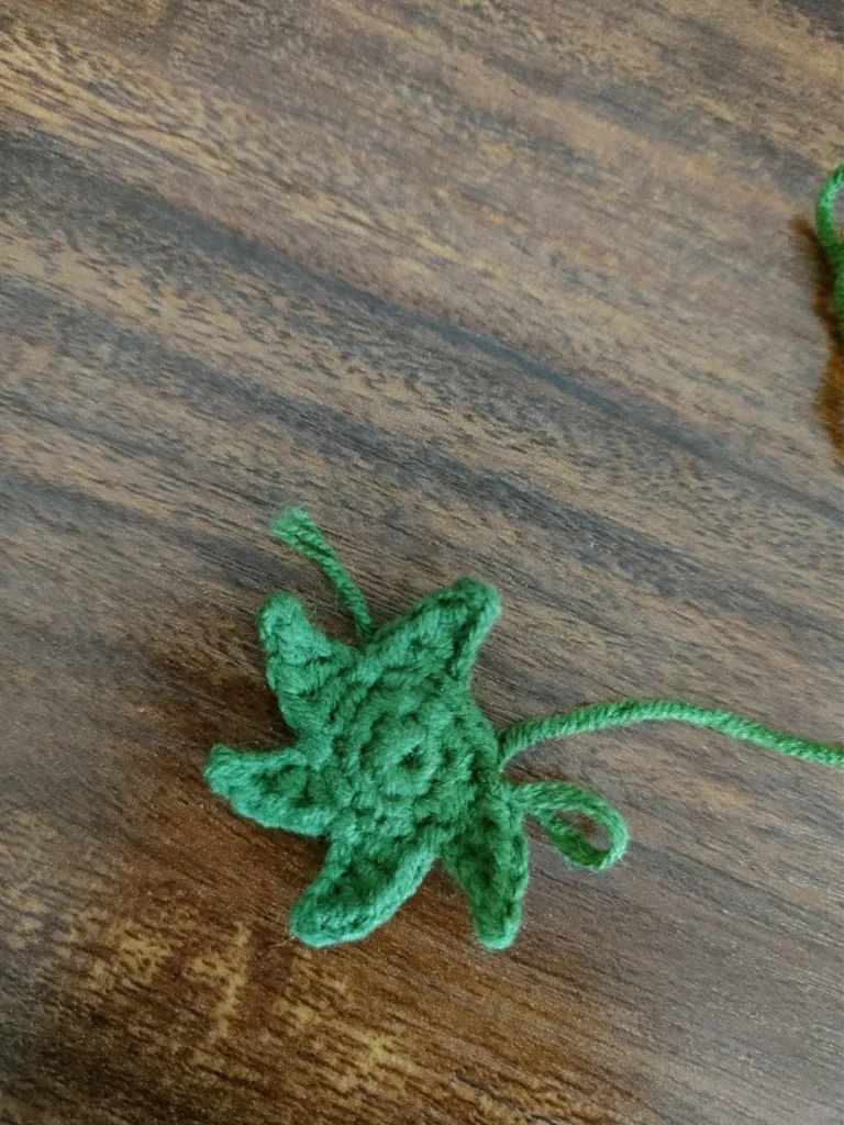 Mini Crochet Strawberry Keychain (Easy Beginner Pattern) 5 Crochet strawberry leaves not forming five points, showing uneven spacing between leaf points