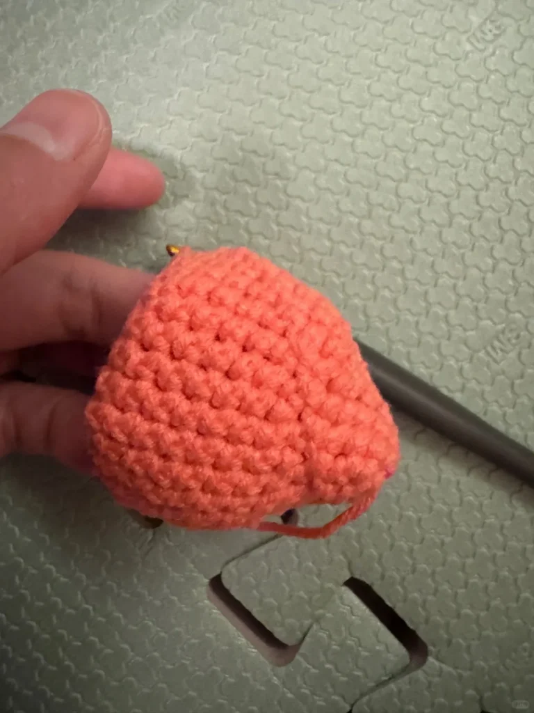 Mini Crochet Strawberry Keychain (Easy Beginner Pattern) 4 Visible seam line on the back of a crochet strawberry caused by incorrect starting stitch placement in continuous rounds