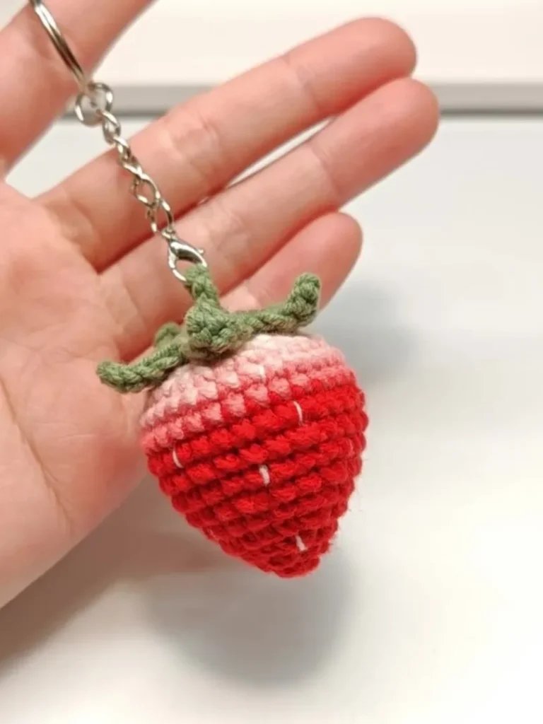 Mini Crochet Strawberry Keychain (Easy Beginner Pattern) 3 Completed mini crochet strawberry keychain with green leaves and embroidered seeds