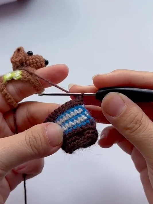 crochet dachshund body with a striped sweater detail in progress
