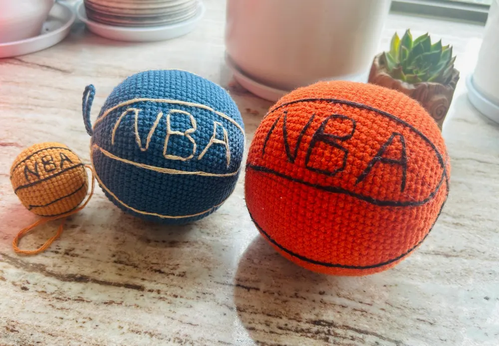 Three crochet basketballs in different sizes with embroidered black lines