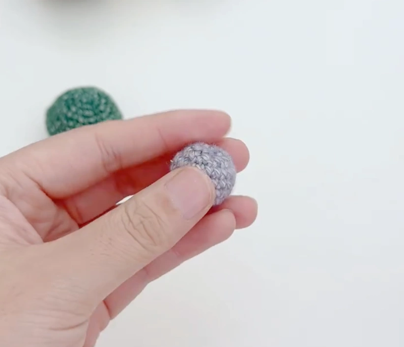 Mini Crochet Turtle Pattern for Beginners: Tiny Amigurumi Turtle 3 Small gray crochet turtle head held in hand before being attached to the body