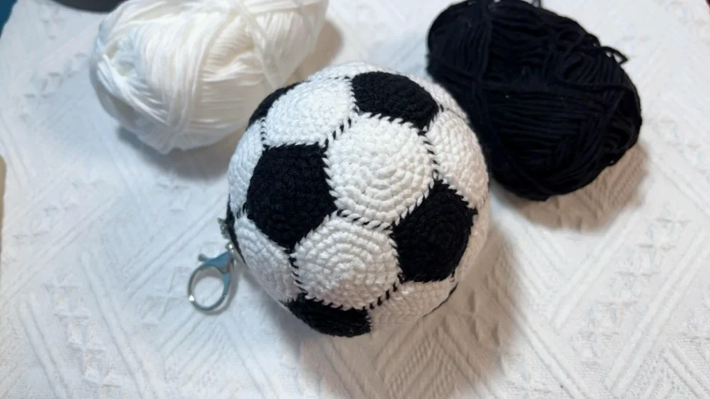 Mini Crochet Soccer Ball Pattern: The Layout Is the Real Trick 6 Close-up of a finished mini crochet soccer ball with black pentagons and white hexagons sewn together