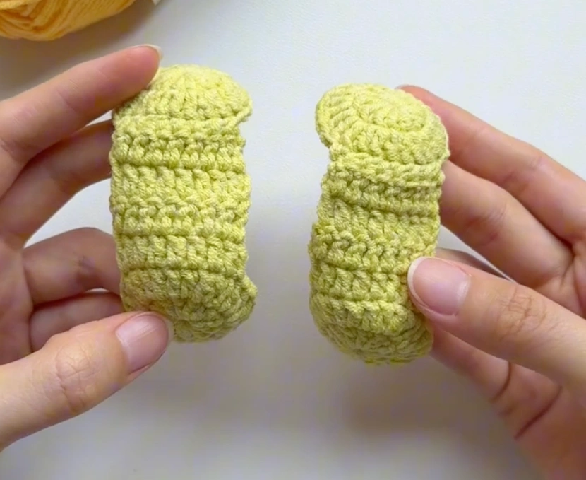 Two yellow-green crochet tennis ball panels before joining